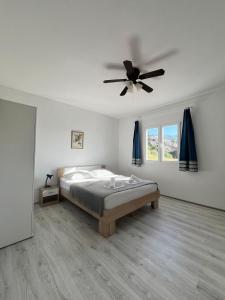 a bedroom with a bed and a ceiling fan at Apartments Peronja Jelsa Seafront in Jelsa