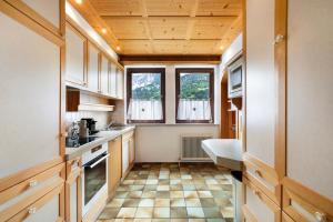 eine Küche mit Holzschränken und Fliesenboden in der Unterkunft Jordis in Vandans
