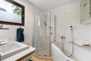 ein weißes Badezimmer mit Dusche und Waschbecken in der Unterkunft Jordis in Vandans
