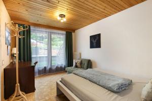 ein Schlafzimmer mit einem Bett und einem Stuhl und einem Fenster in der Unterkunft Jordis in Vandans