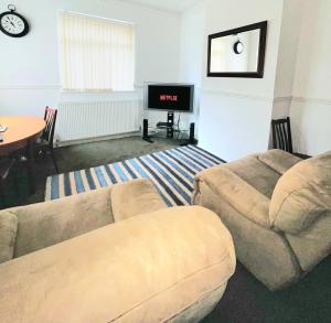 a living room with two couches and a tv at The Trio Place in Middlesbrough