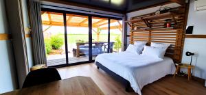 une chambre avec un lit et une grande fenêtre dans l'établissement La Luna - Tiny House Spa - Romantique & Nature, à Saint-Yan