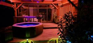 - un bain à remous au milieu d'une terrasse la nuit dans l'établissement La Luna - Tiny House Spa - Romantique & Nature, à Saint-Yan