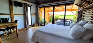 une chambre avec un lit et un bureau avec une fenêtre dans l'établissement La Luna - Tiny House Spa - Romantique & Nature, à Saint-Yan