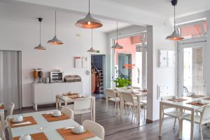 a kitchen and dining room with white tables and chairs at Residência Maciel in Peniche
