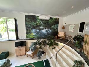 a lobby with a spiral staircase with a painting on the wall at Bed&Breakfast Kamersven in Maarheeze