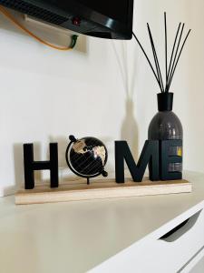 uno scaffale di legno con la parola hisme accanto a un vaso di NencioniHouse- Modern comfort close to city center a Firenze