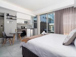 Un dormitorio con una cama grande y una cocina. en Cape Town Self-Catering, en Ciudad del Cabo