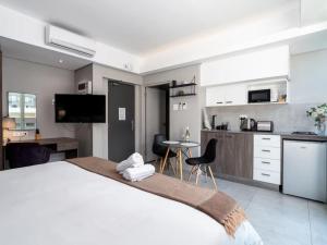 Un dormitorio con una cama grande y una cocina. en Cape Town Self-Catering, en Ciudad del Cabo 24 fotos más