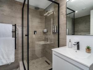 Un baño con ducha y lavabo blanco. en Cape Town Self-Catering, en Ciudad del Cabo