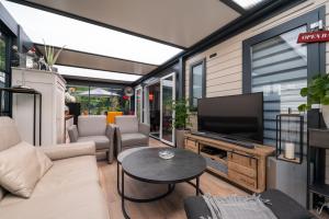 Una sala de estar con un sofá y un televisor. en Mobilhome - Piscine - Premium, en Erdeven