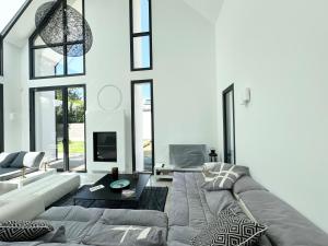 a living room with a couch and a table at Superbe Villa contemporaine avec piscine, Sainte Marine in Combrit