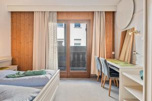Un dormitorio con una cama, un escritorio y una mesa. en Biobauernhof Toellerhof, en Lagundo