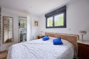 Un dormitorio con una cama con almohadas azules. en Margaux - Proche du Port, en Barneville-Carteret
