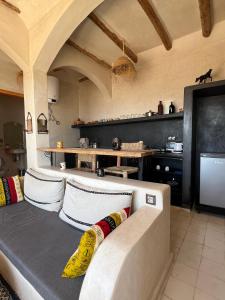 a living room with a couch with pillows on it at SurfAppart Morocco in Tamraght Ouzdar