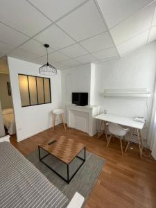 a living room with a table and a desk at Le Charme Provençal - Centre-ville - Calme in Digne-les-Bains