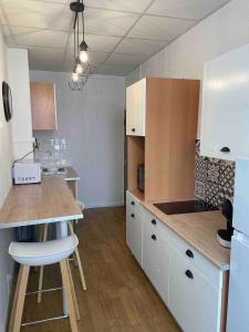 a kitchen with white cabinets and a wooden counter top at Le Charme Provençal - Centre-ville - Calme in Digne-les-Bains
