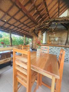 a wooden dining table and chairs in a room at Sumatra Cheeky Monkeys Villa, Trekking and Tours in Bukit Lawang