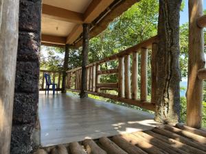 a porch of a log cabin with a tree at Mountain Inn Resort in Buikwe
