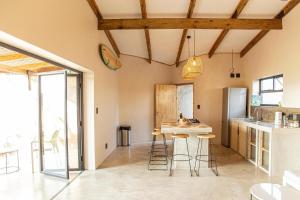 a kitchen with a table and stools in a room at Modern 2 bed House - Mango in Malkerns