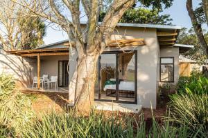 a small house with a tree in front of it at Modern 2 bed House - Mango in Malkerns