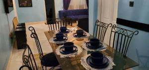 a dining table with bowls and saucers on it at TwinVilleCove, affordable villas located in Ajah in Obalende