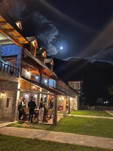 a group of people standing outside of a building at night at Bujtina Harusha in Theth