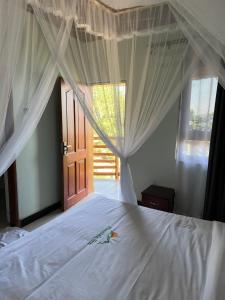 a bedroom with a white bed with a canopy at Mountain Inn Resort in Buikwe