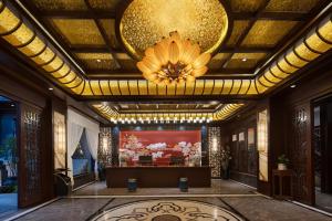永顺Ancient Dream Hotel的大堂设有金色天花板和吊灯