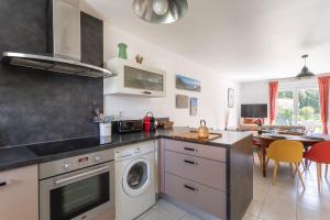 a kitchen with a washing machine and a dining room at La Pointe aux Chèvres - 10min à Pied de la Plage in Frehel +7 photos