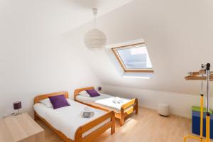 two beds in a room with a window at La Pointe aux Chèvres - 10min à Pied de la Plage in Frehel