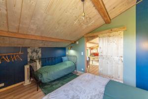 a bedroom with a bed and a wooden ceiling at Le Nid de Bluenn in Vosbles +7 photos