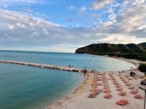 a beach with chairs and umbrellas in the water at Casa Mami 2 in Mattinata