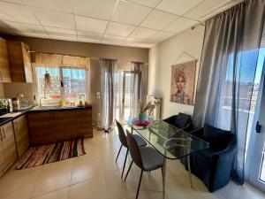 a kitchen and dining room with a glass table and chairs at Alpha Apartment View in Serres