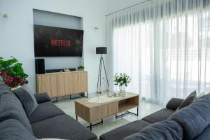 a living room with a couch and a table at Emma - Elena Peris Villas, By Idealstay Experience in Gouves