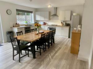 a kitchen with a wooden table and black chairs at Bright, Spacious 5-Bed, 4-Bathroom home on Loch Soy in Portsoy