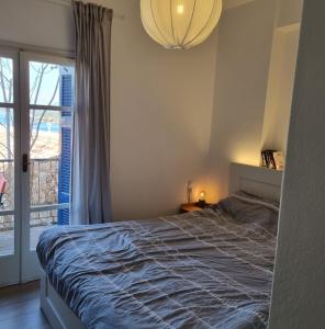 a bedroom with a bed and a large window at MARINA'S HOUSE - Serenity in Poros