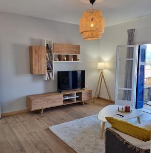 a living room with a tv and a couch at MARINA'S HOUSE - Serenity in Poros