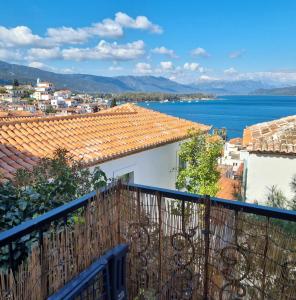 a view of a city and the ocean from a balcony at MARINA'S HOUSE - Serenity in Poros