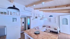a white living room with a table and a couch at Tonea's Houses in Himare