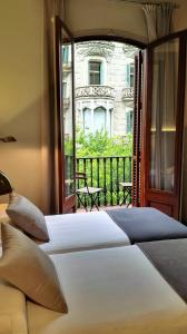 a bedroom with a large bed and a balcony at Casa Abamita in Barcelona