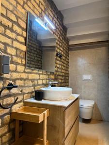 a bathroom with a sink and a brick wall at Villa Mediterrane - Apartment Bologne in Frankenthal