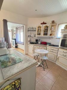 a kitchen with a counter and a table in it at Maison in La Celle-sous-Gouzon +12 photos