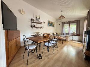 a dining room with a wooden table and chairs at Maison in La Celle-sous-Gouzon
