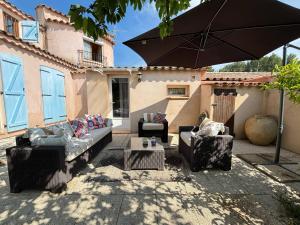 a patio with two couches and an umbrella at Maison in La Celle-sous-Gouzon