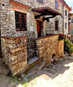 an old stone house with a gate in front of it at La Casa dell'Affinatore in Gombitelli