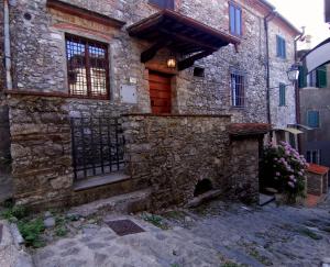 a stone house with a gate and a stone wall at La Casa dell'Affinatore in Gombitelli