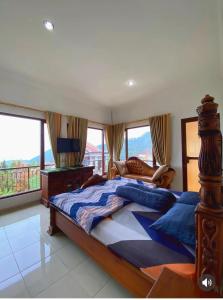 a bedroom with a large bed with a view at Villa Kusuma Tawangmangu in Tawangmangu +23 photos