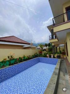 a swimming pool in front of a house at Villa Kusuma Tawangmangu in Tawangmangu