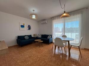 a living room with a blue couch and a table at Magnifico apartamento de playa in Moncófar